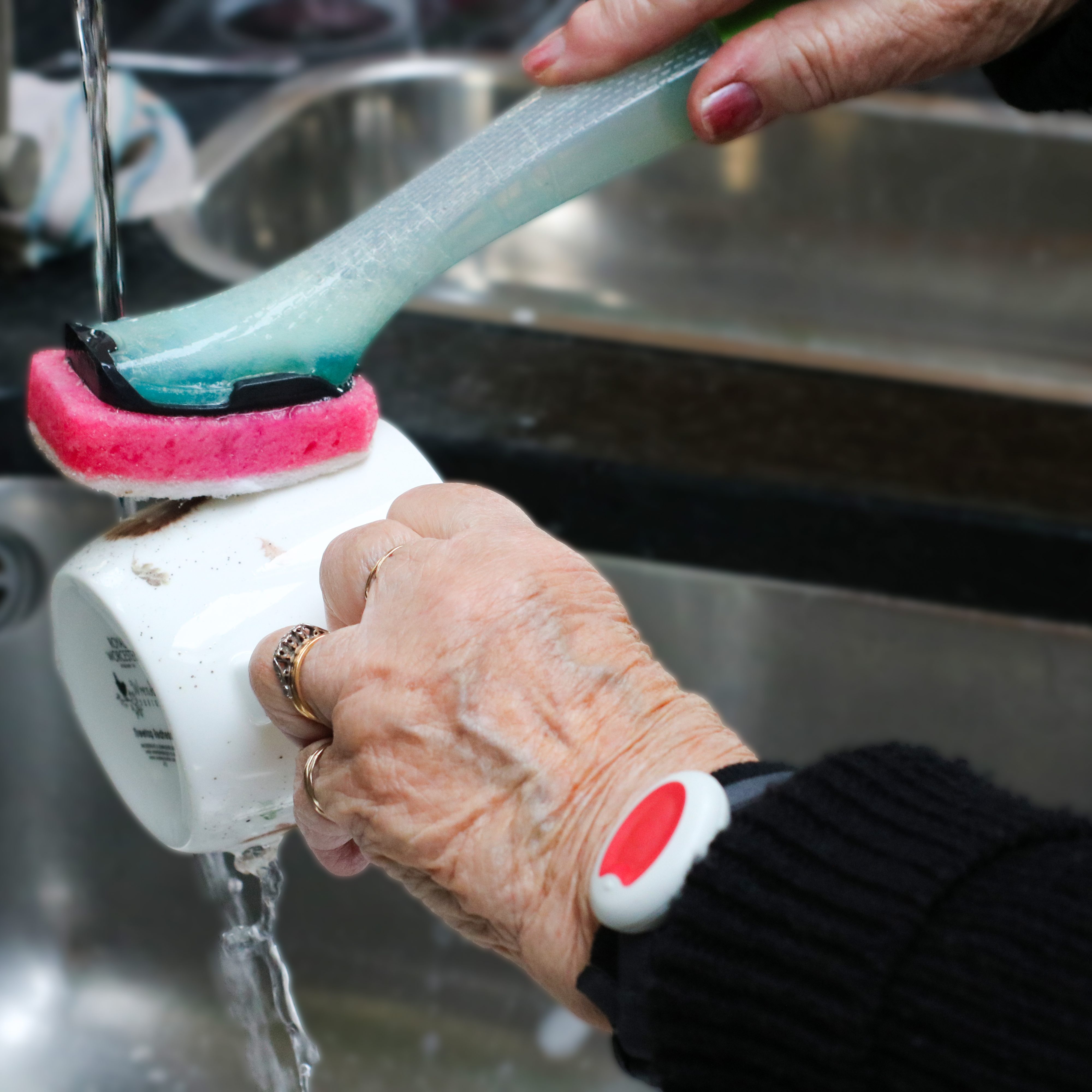 Elderly lady wearing her pendant whilst washing up